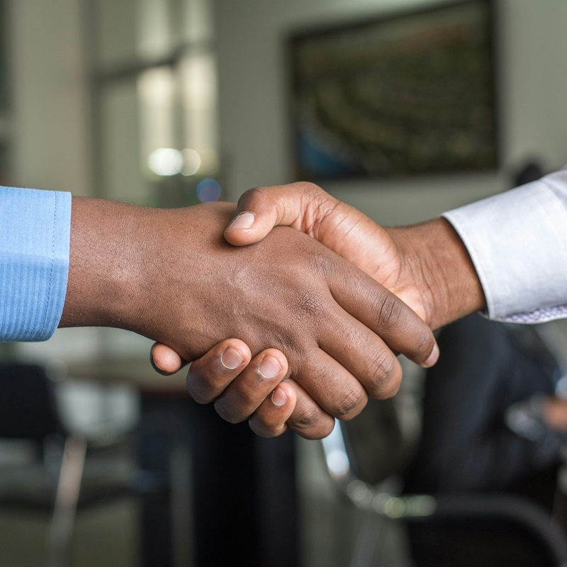 Due Diligence when buying a business illustrated by two businessmen shaking hands.